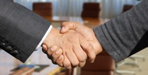 Two men in suits shaking hands