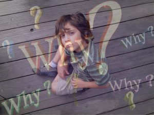 Little boy sitting on the ground surrounded by the question, "Why?"